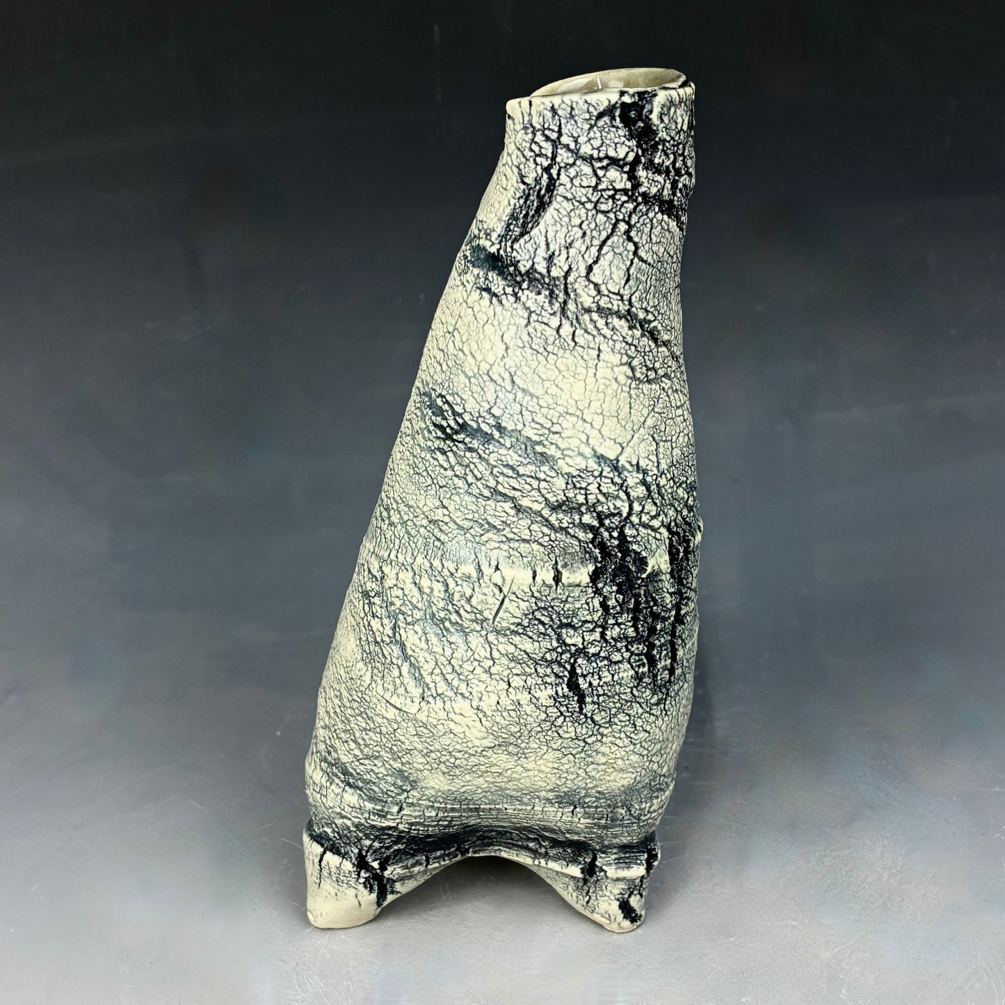 Ceramic vase with textured surface on a gray background