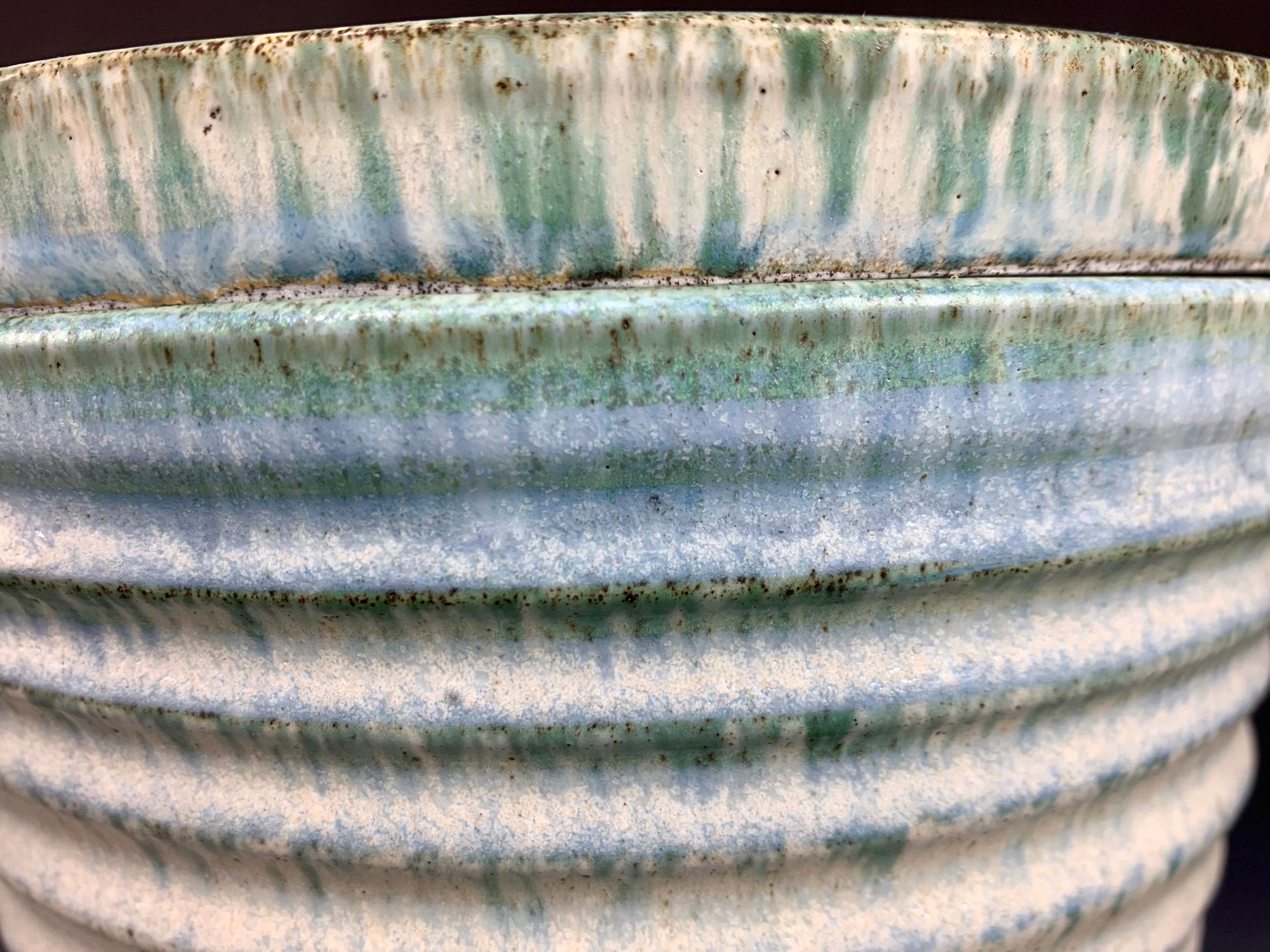 Side view of Blue and White storage container on dark background, lid on