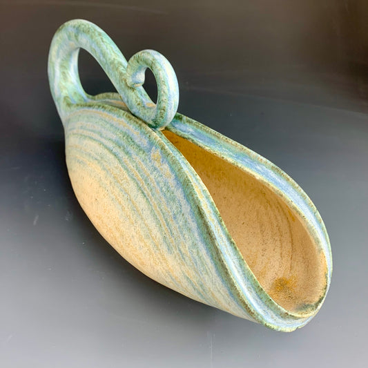Side view of handmade yellow and blue watering can for plants