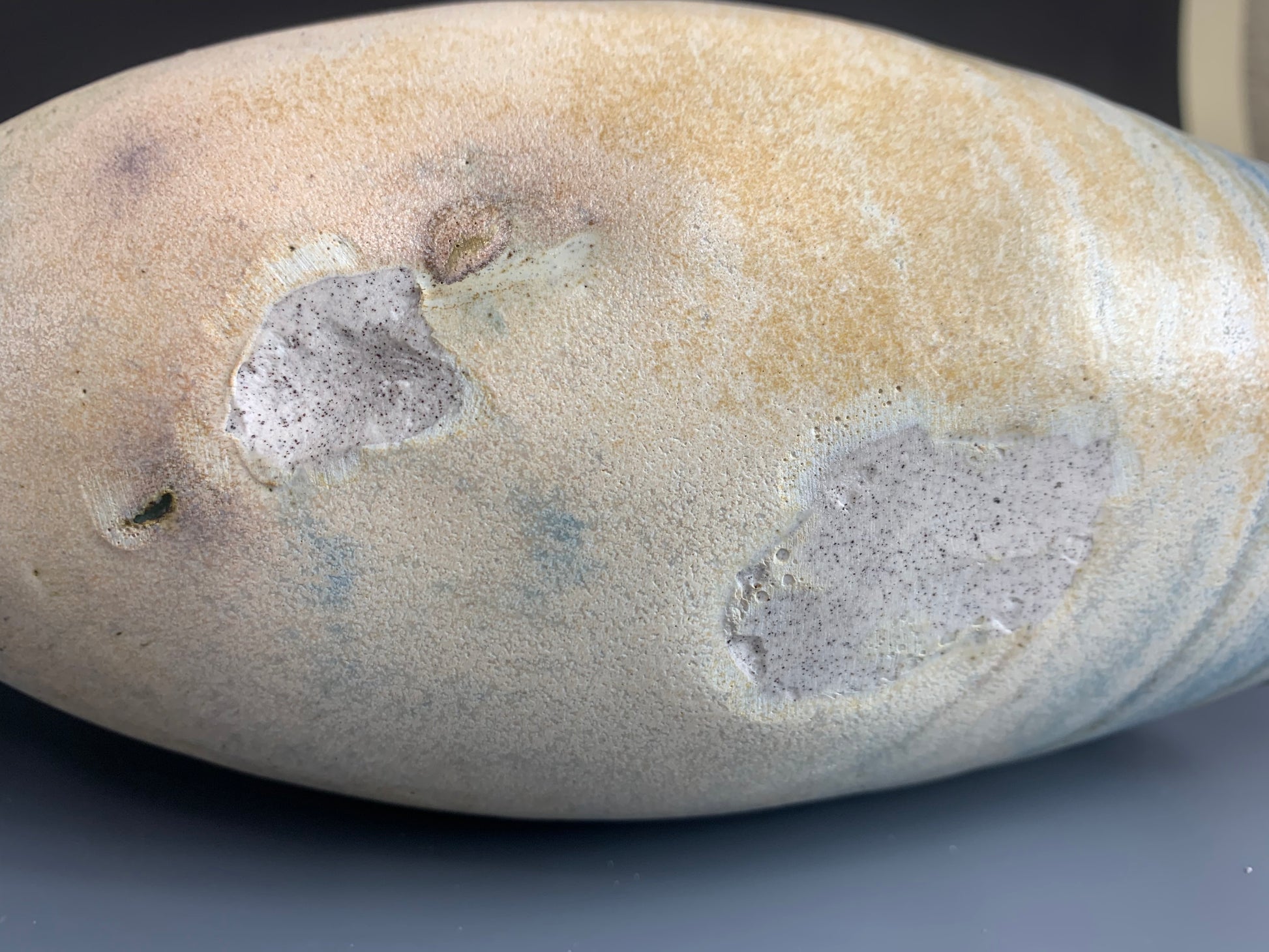 Bottom view of handmade yellow and green watering can for plants, heavy surface marring visible