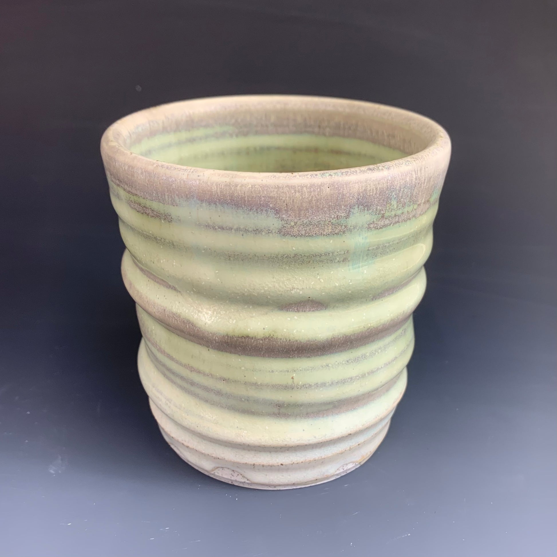 Green and Gray Wheel thrown cup on dark  background