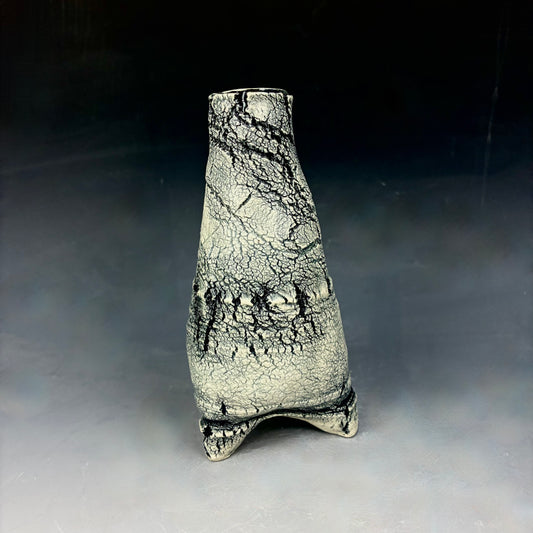 Ceramic vase with textured surface on a gray background
