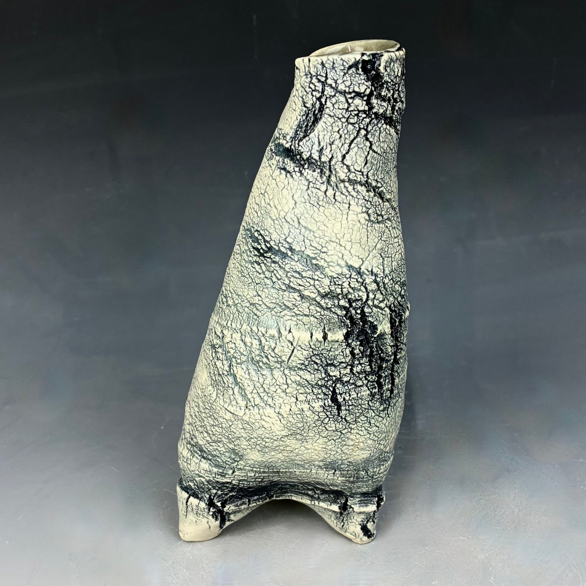 Ceramic vase with textured surface on a gray background