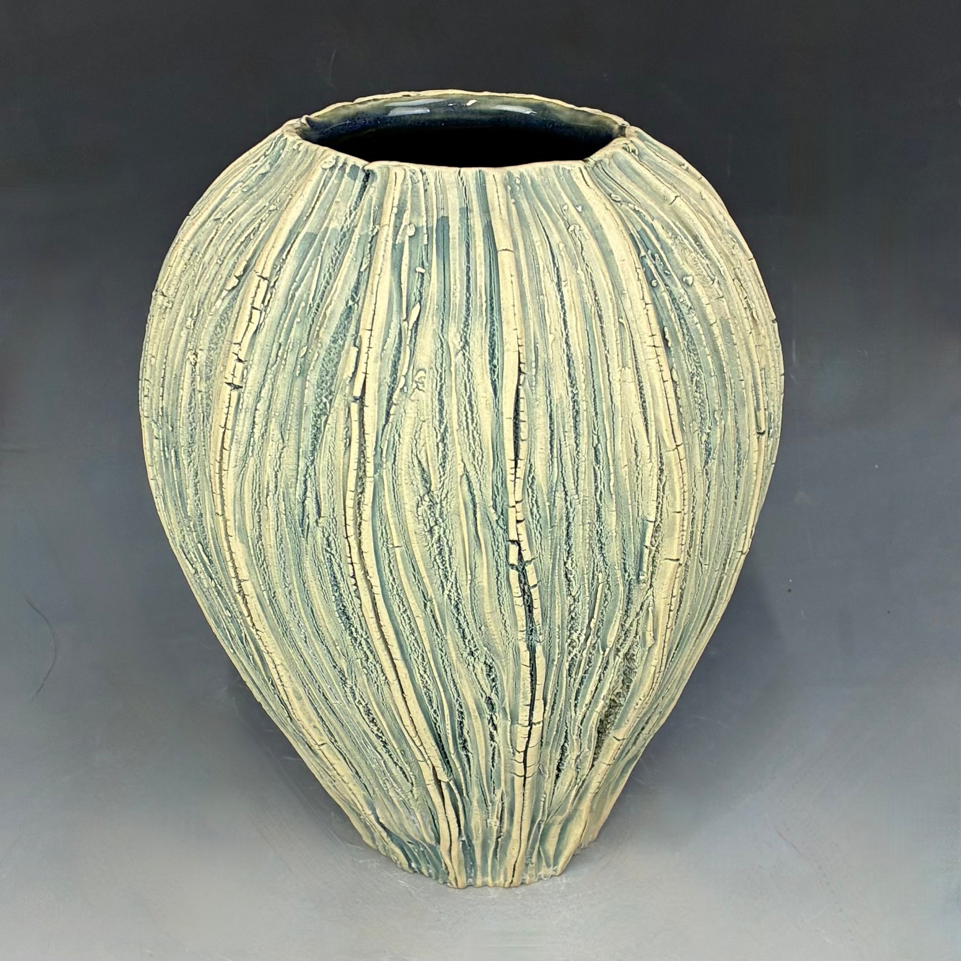 Decorative ceramic vase with striped pattern on a gray background