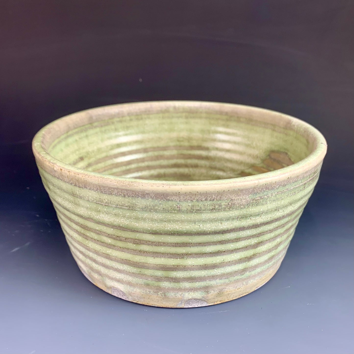 Above view of Green and Gray wheel thrown bowl on dark background