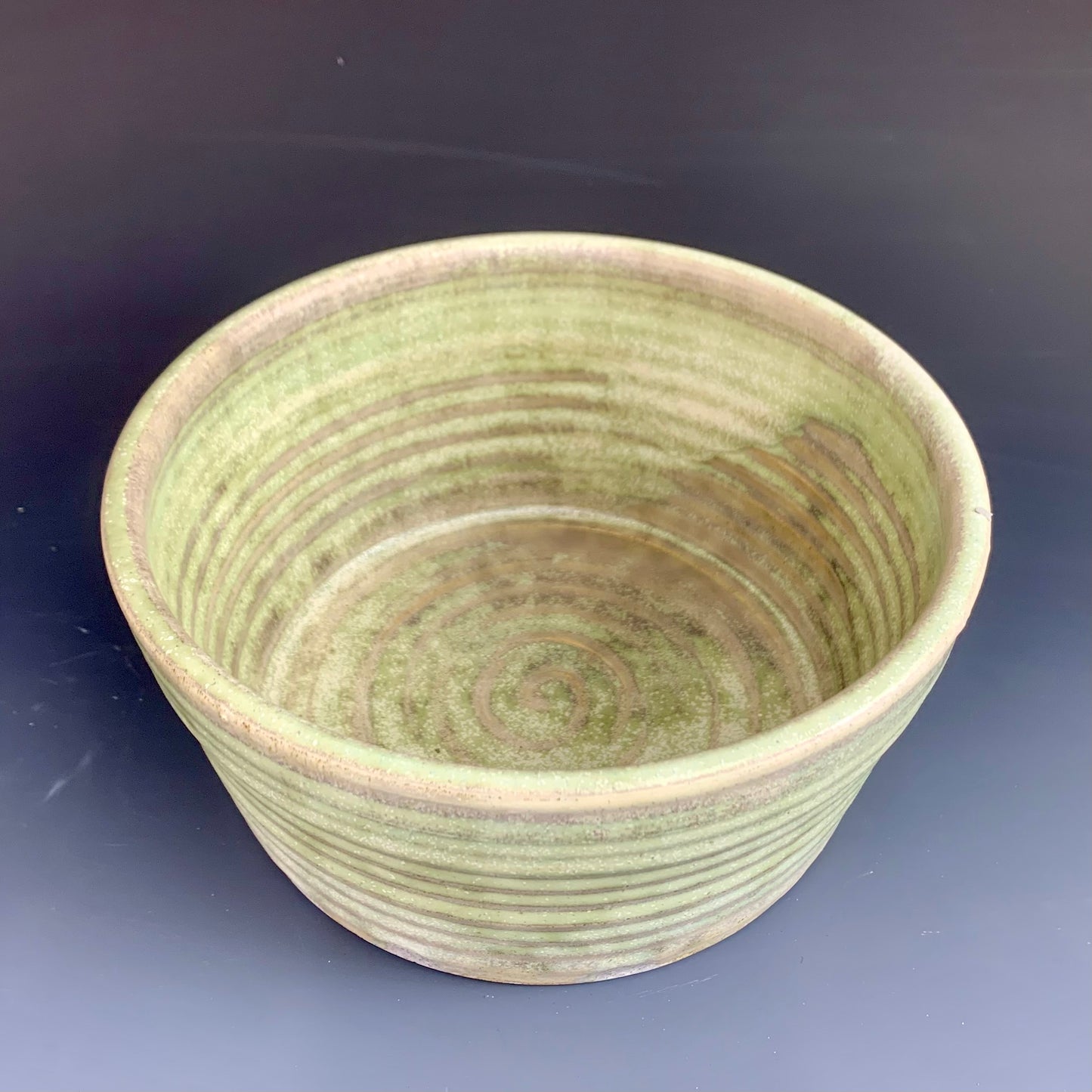 Inside view of Green and Gray wheel thrown bowl on dark background