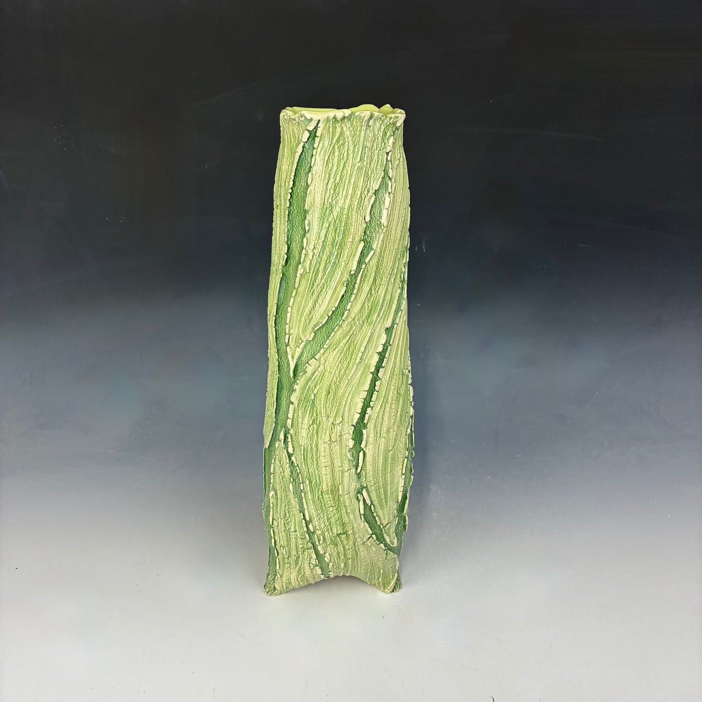 Green textured ceramic vase on a gradient background