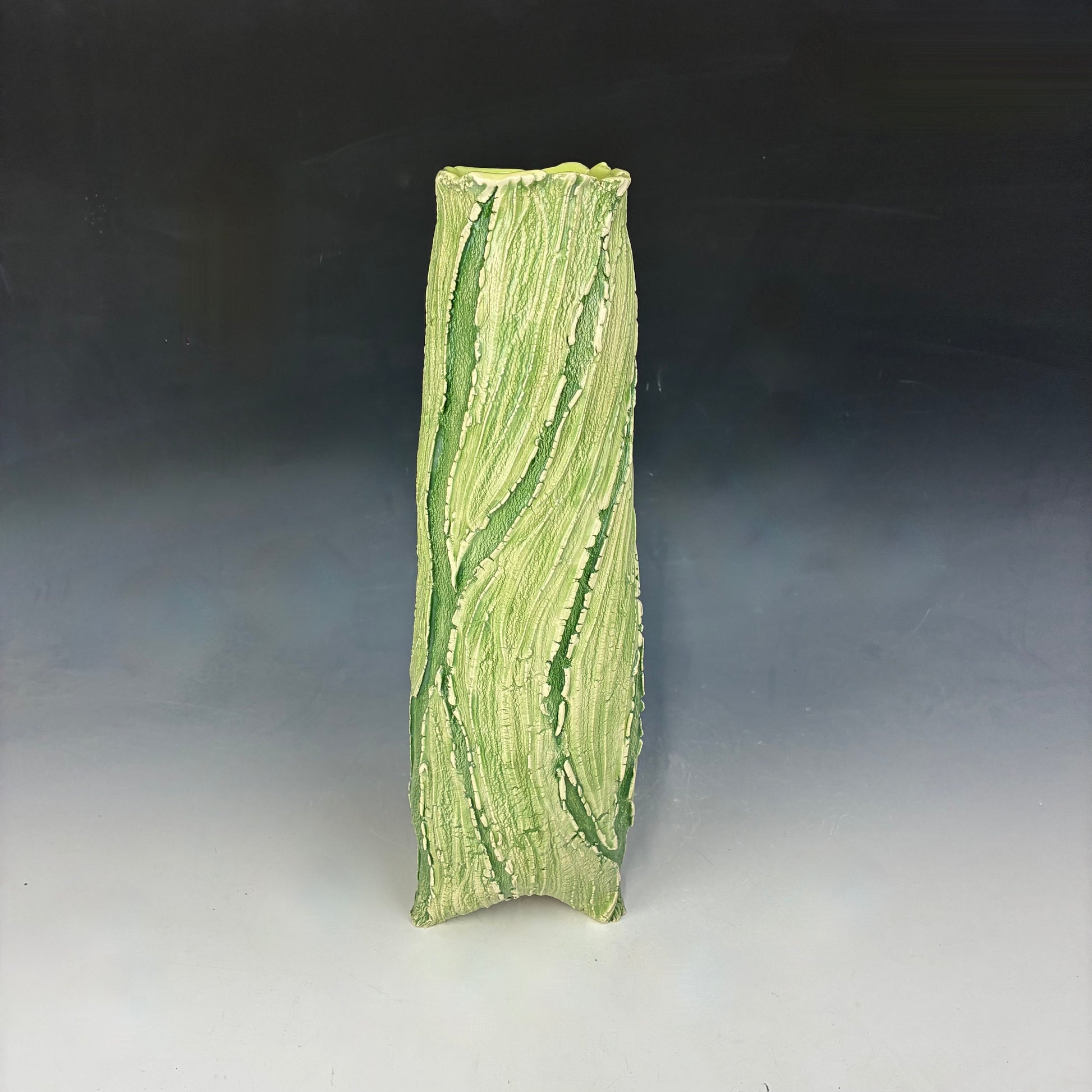 Green textured ceramic vase on a gradient background