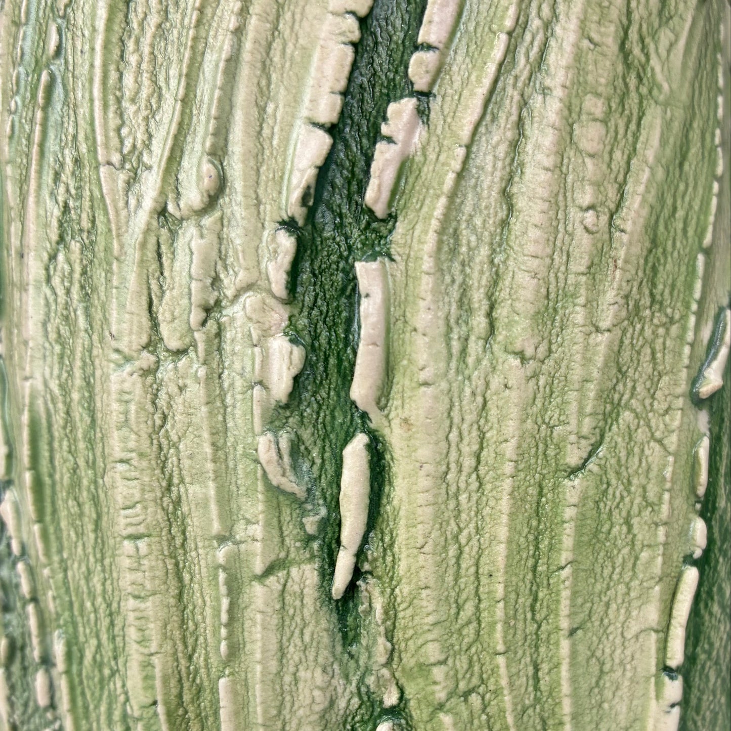 Close-up of ceramic surface texture layered with green pigment