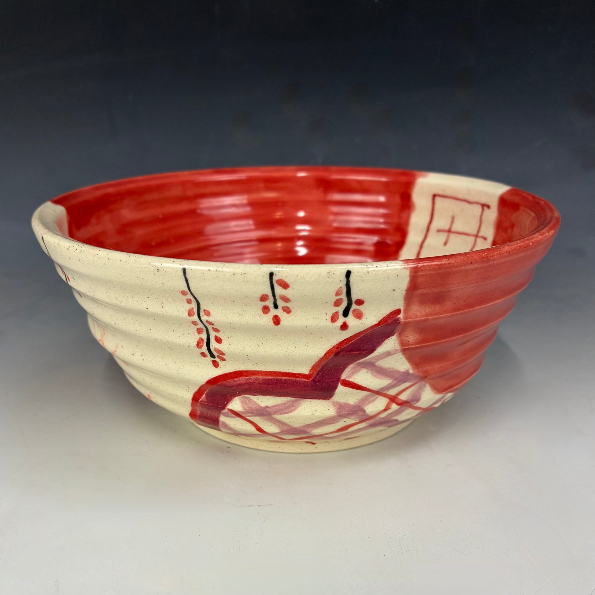 Ceramic bowl with red and beige design on a gray background