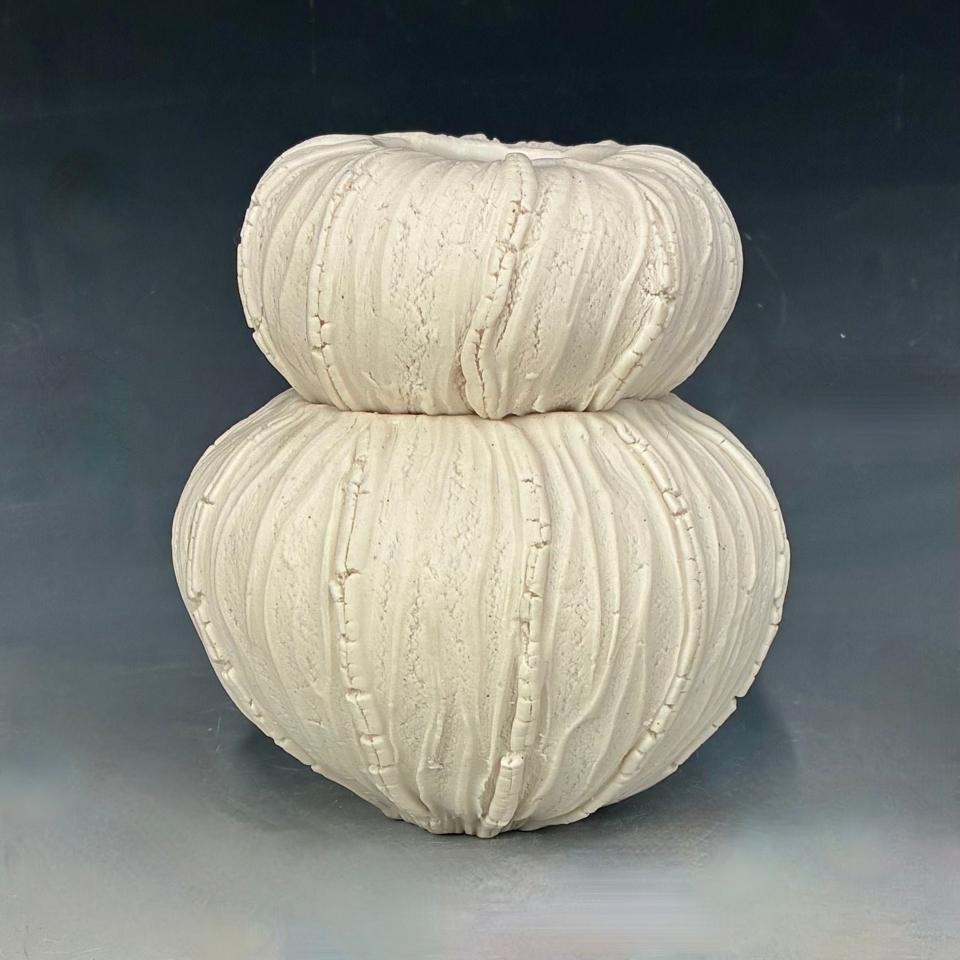 Textured ceramic vase on a gray background