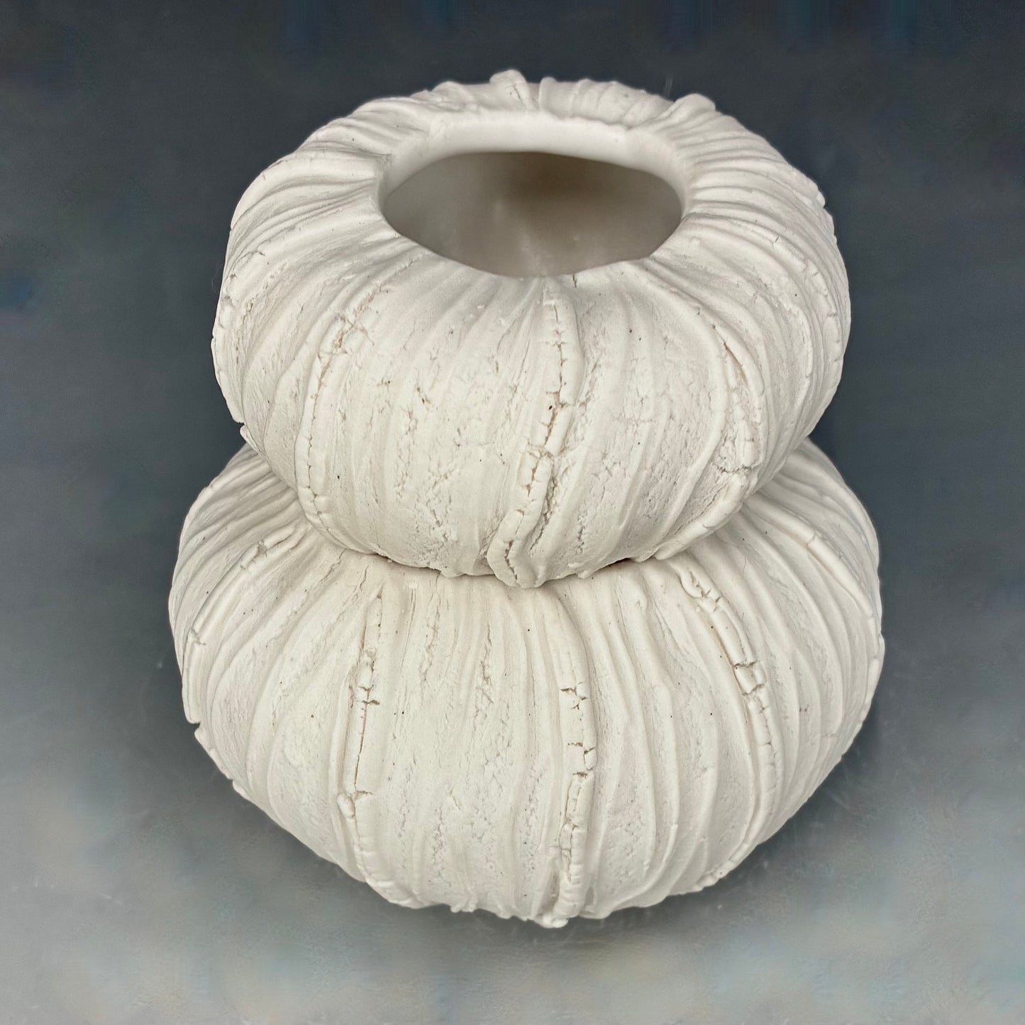 White textured ceramic vase on a gray background