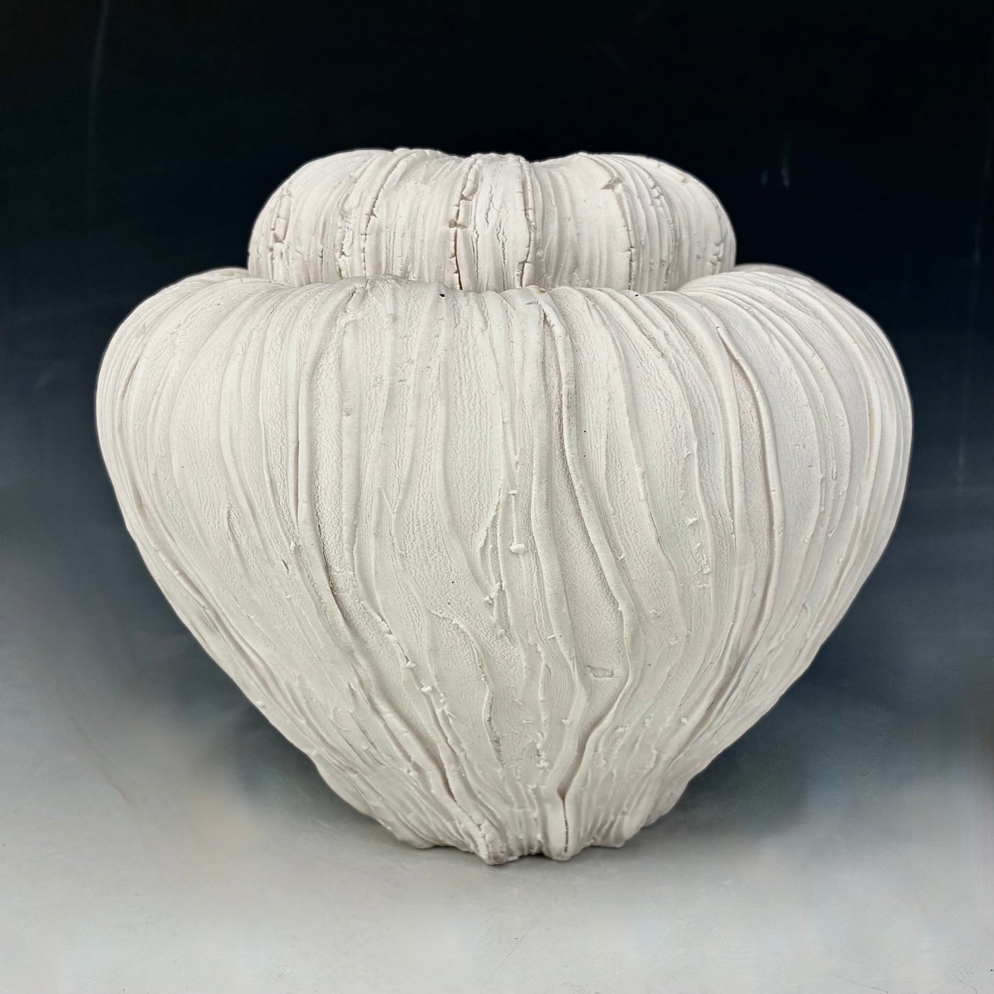 Textured ceramic vase on a dark background