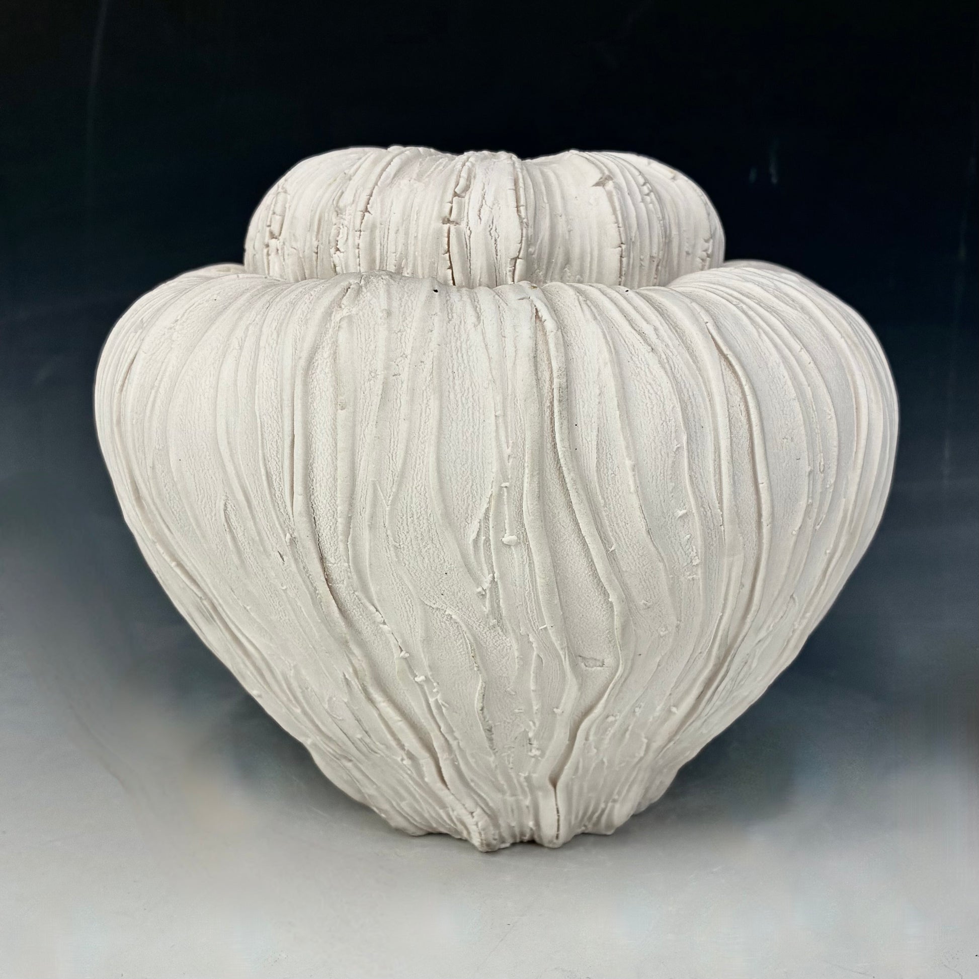 Textured ceramic vase on a dark background