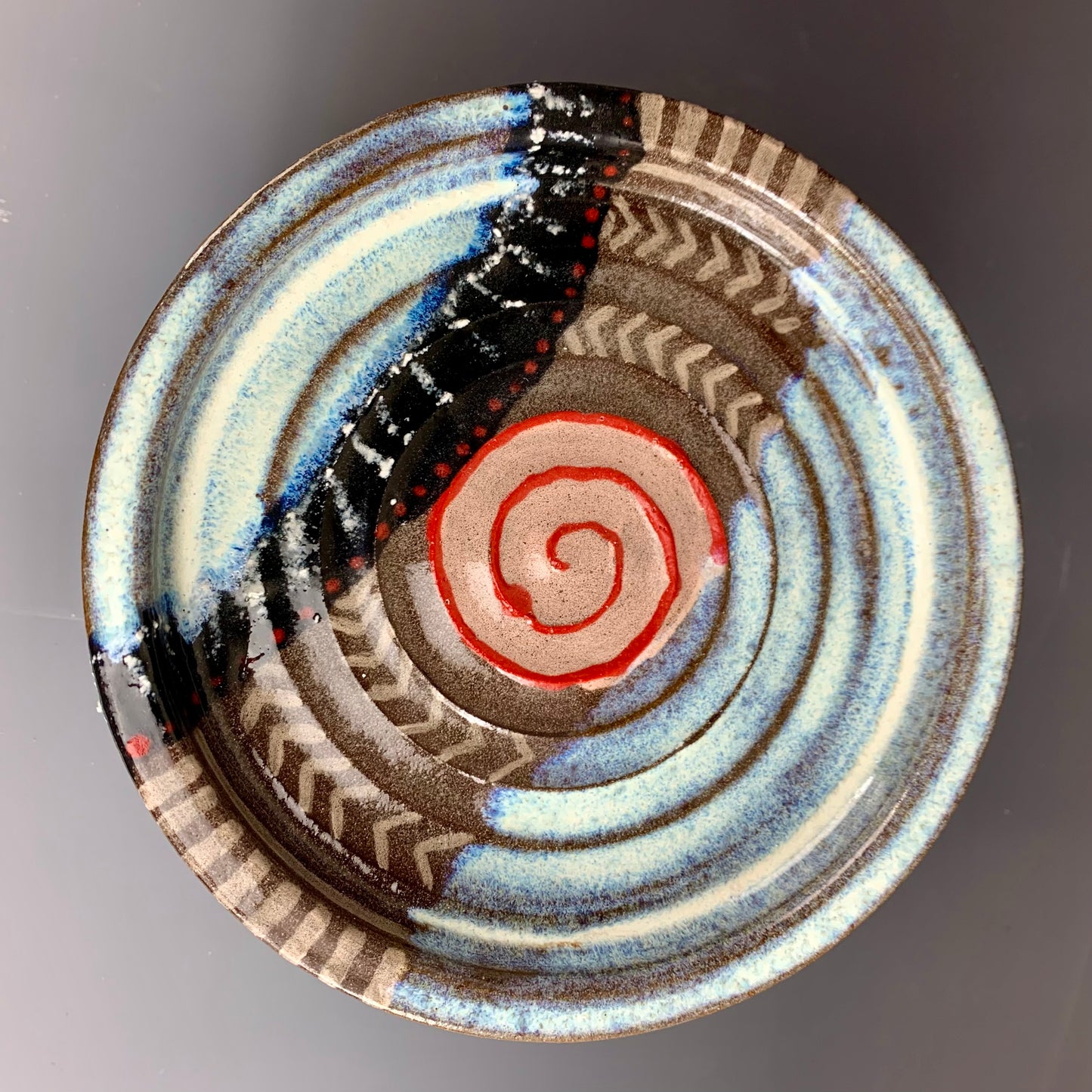 Above view of Brown, White, Black and Red decorated ceramic storage container, Lid on